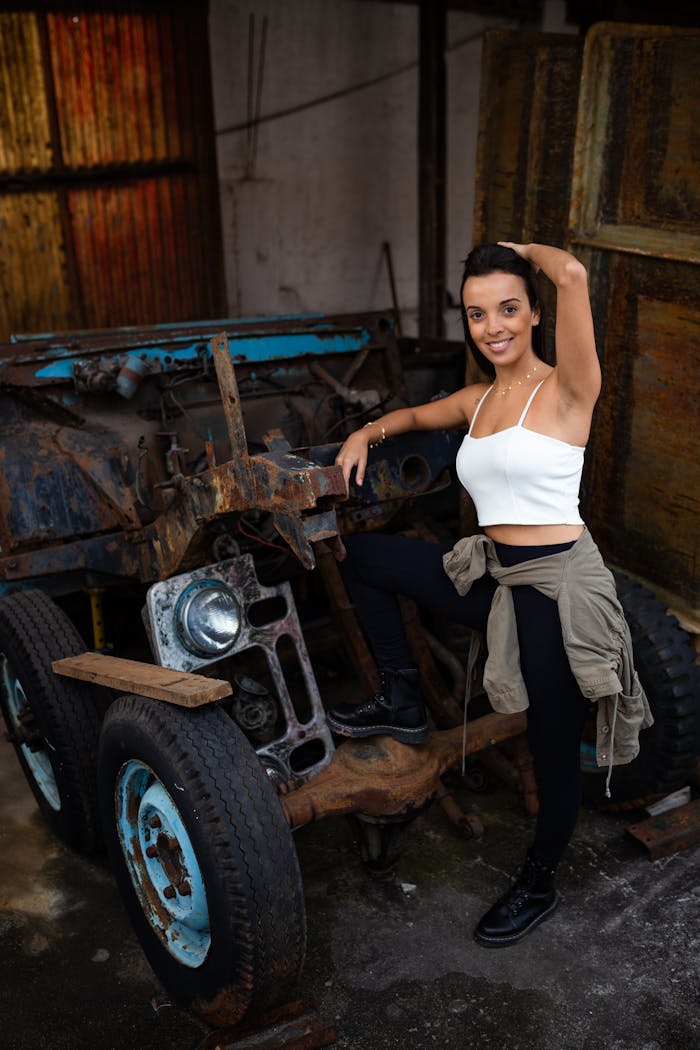 Portrait of a smiling woman in São Paulo, posing with rustic car elements.